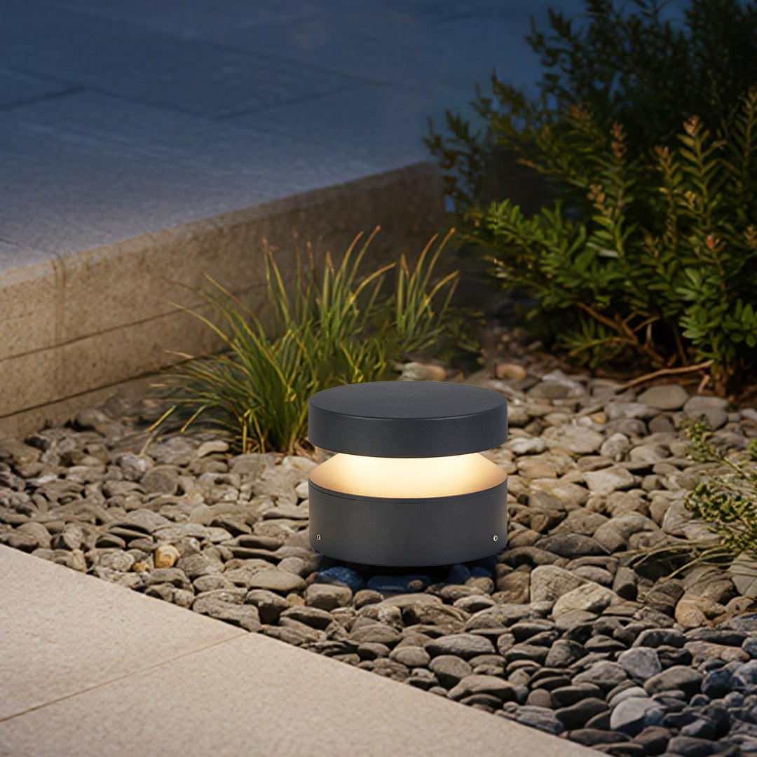 110v landscape lights installed on decorative gravel near steps, emitting a warm glow for outdoor safety lighting.