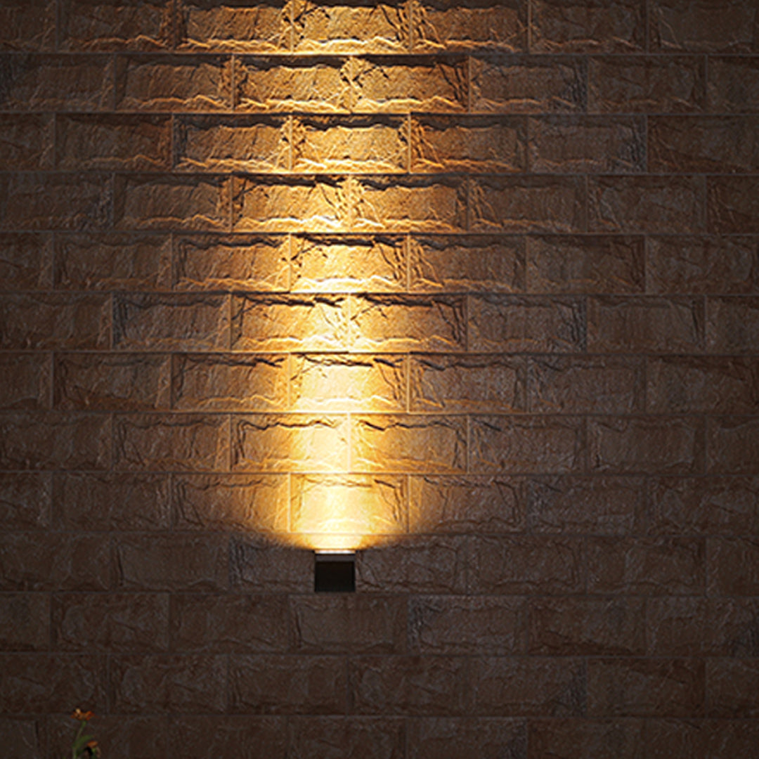 Close-up view of bronze outdoor light fixture showing curved arm and mounting details