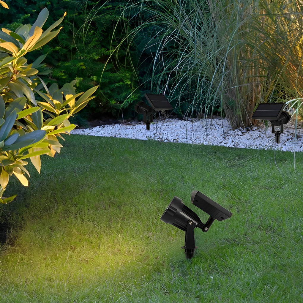 Adjustable ground spike solar lights lighting a grassy yard, creating a soft outdoor nighttime ambiance.