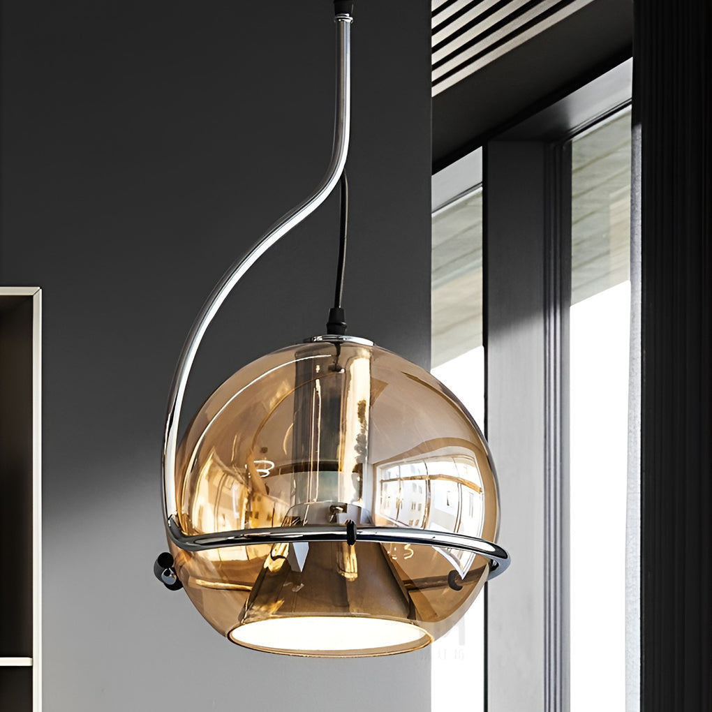 Amber glass globe pendant light close-up near a window, highlighting curved metal arm and tinted glass shade.