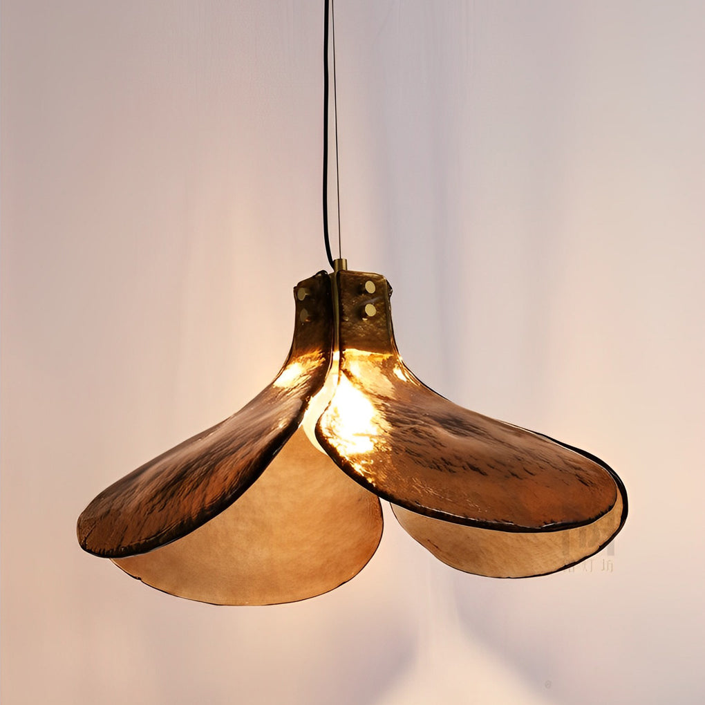 Amber glass pendant light providing ambient light beside a green accent wall.