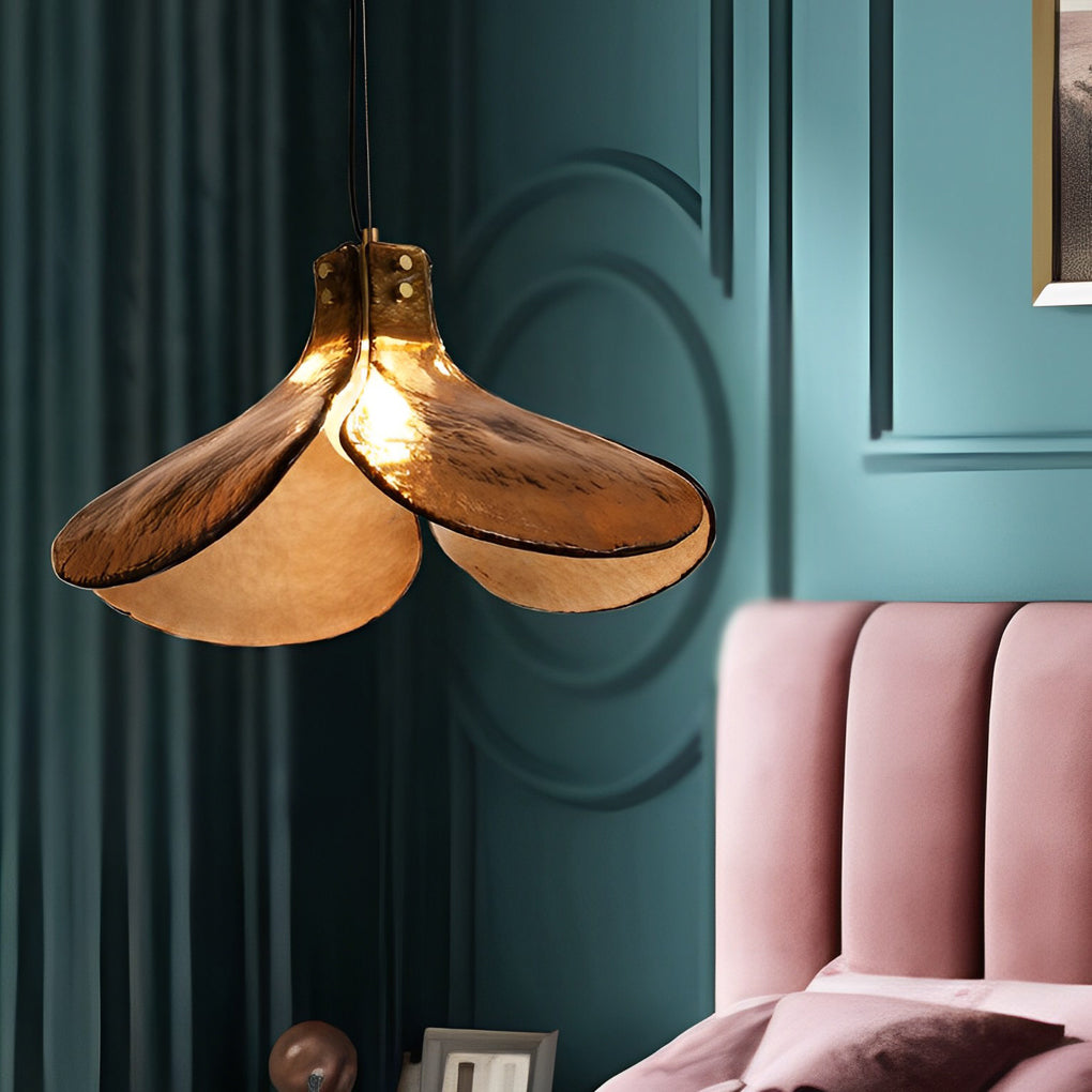 Amber glass pendant light casting a gentle glow in a stylish indoor setting.