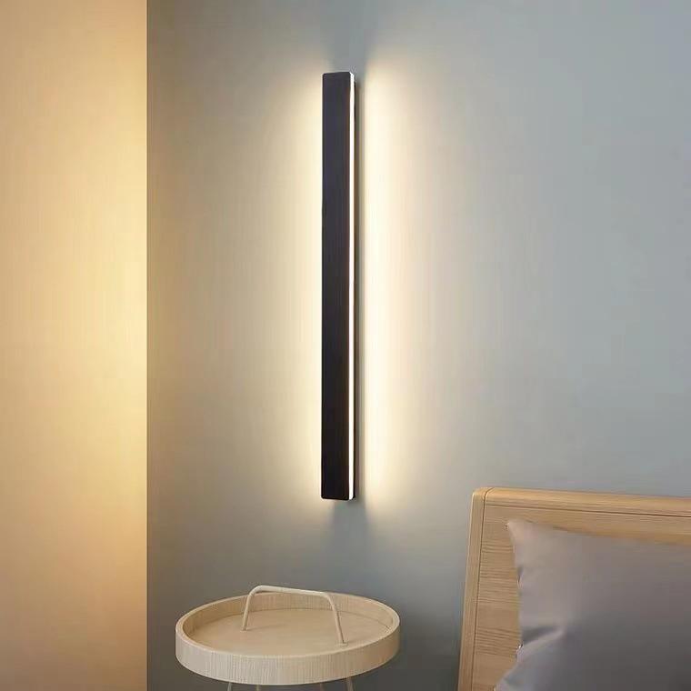 Long outdoor wall lights providing ambient illumination, mounted beside wooden door for modern exterior lighting.