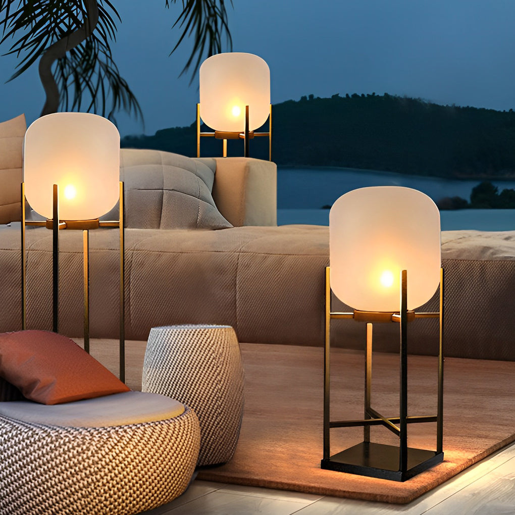 Outdoor standing light providing ambient lighting for modern outdoor sofa and coffee table setup.