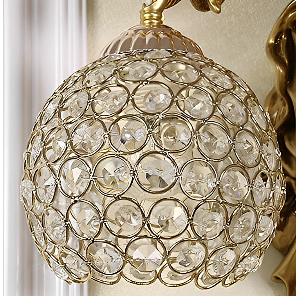 Crystal globe shade detail of angel wall sconce highlighting faceted glass design.