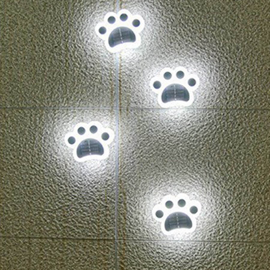 Animal paw step stairs light with a solar panel, displayed on gravel.