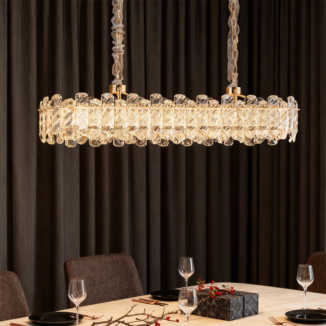Architectural Nordic chandelier with glass shade chandelier influence in elongated linear design above modern black dining table.