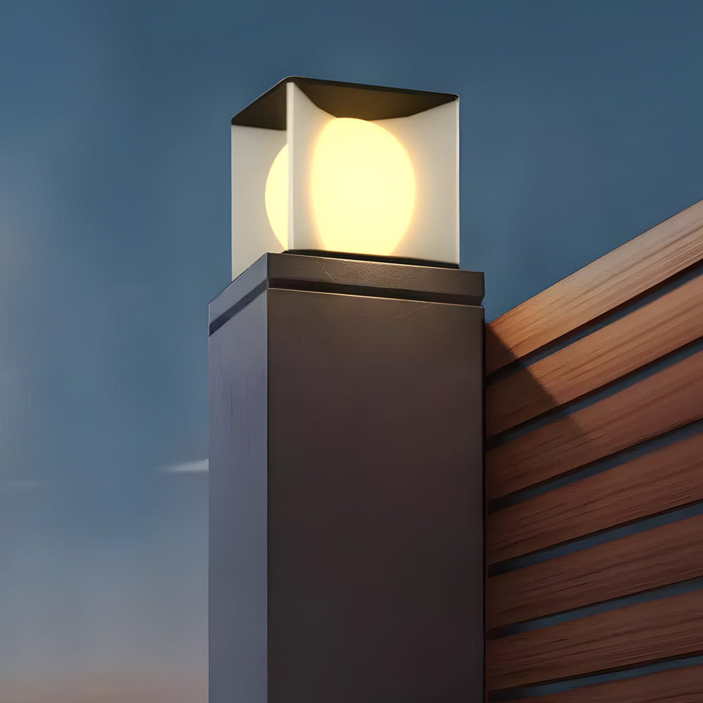 Architectural solar cube light mounted on wooden post creating dramatic evening ambiance