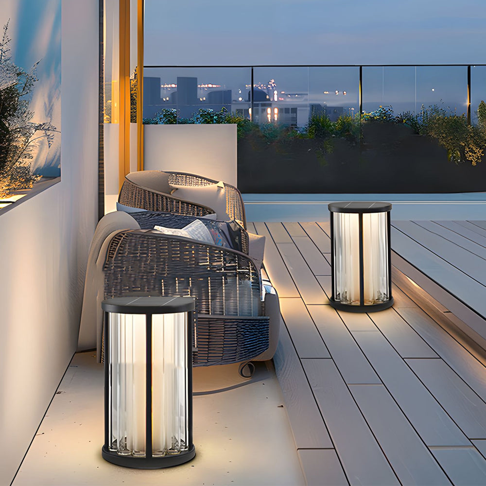 Rooftop terrace showcasing multiple cylindrical floor lamps creating intimate evening ambiance with city skyline backdrop