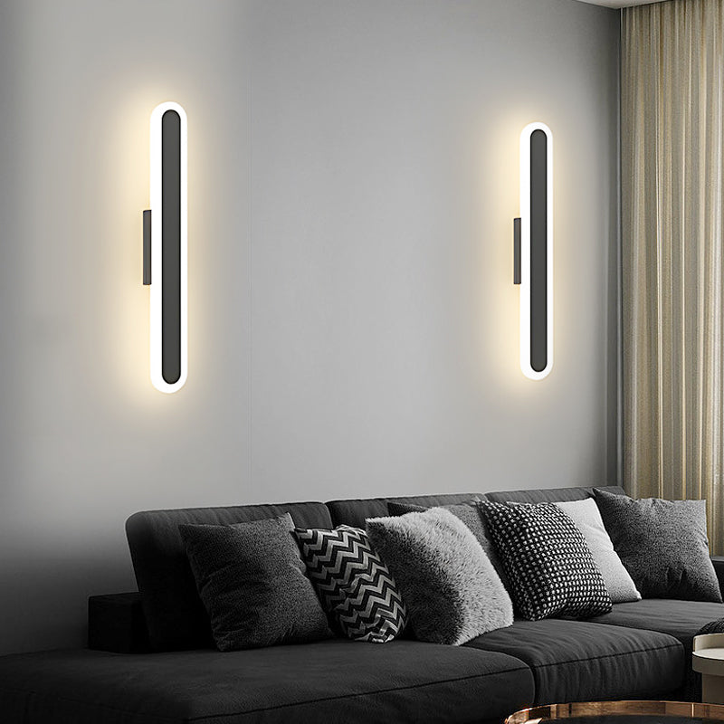 Bar wall light providing soft illumination in a contemporary living room with a gray sofa.