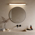 Bath bar vanity light with a sleek design, illuminating a modern round bathroom mirror.