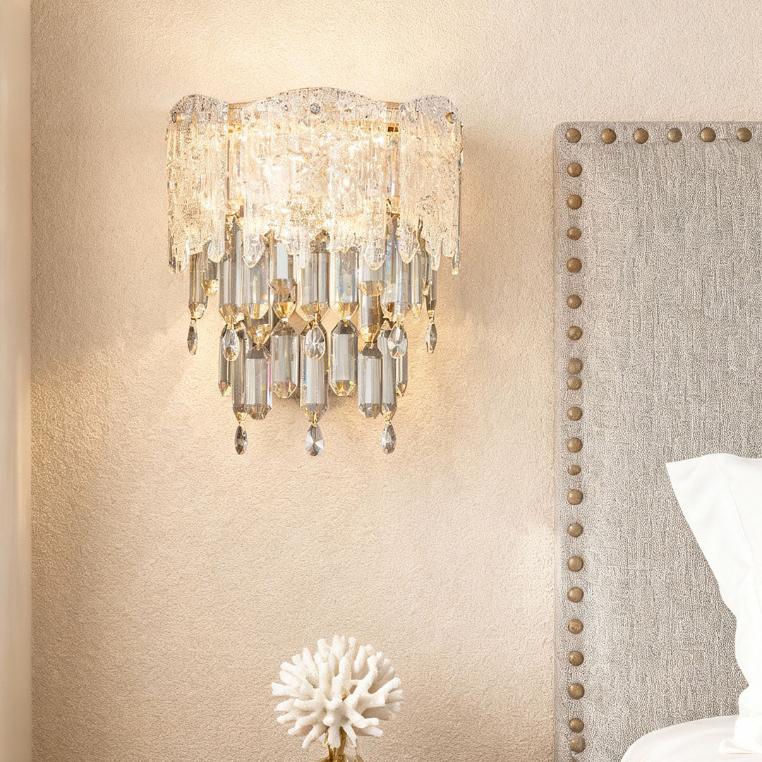 Bedroom accent wall illuminated by elegant crystal wall sconce lighting with warm glow.