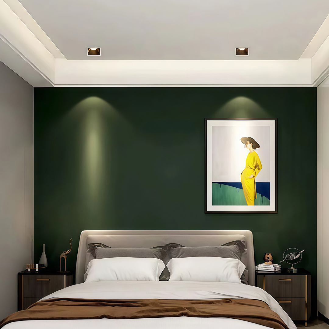 Bedroom interior showcasing square LED downlights highlighting a painting on a dark green accent wall.