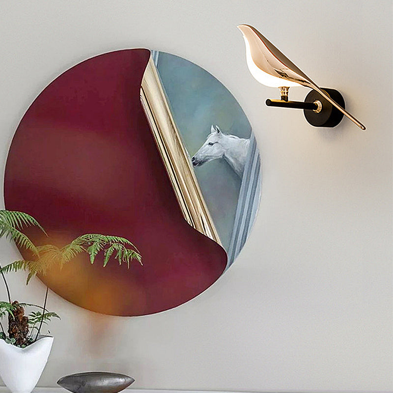 Bird wall light mounted beside a round decorative mirror on a wall