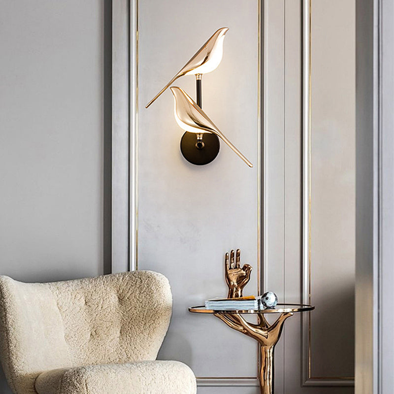 Bird wall light placed above a modern accent chair in a minimalist room