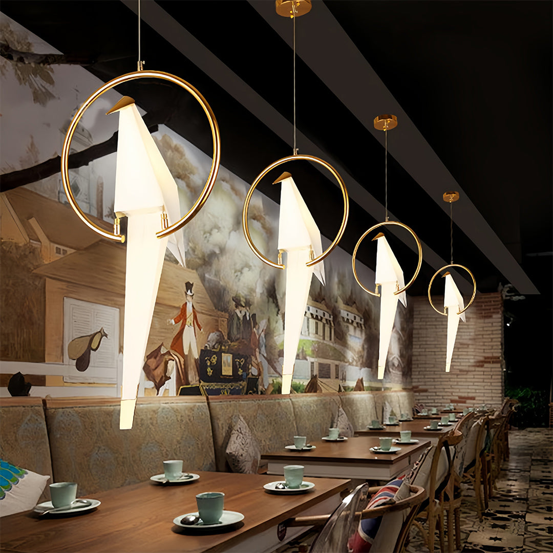 Bird wall light in a modern living room with a gray sofa and decorative plants.