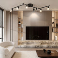 Black adjustable ceiling lights installed in a modern living room, providing flexible spotlight illumination for media walls.