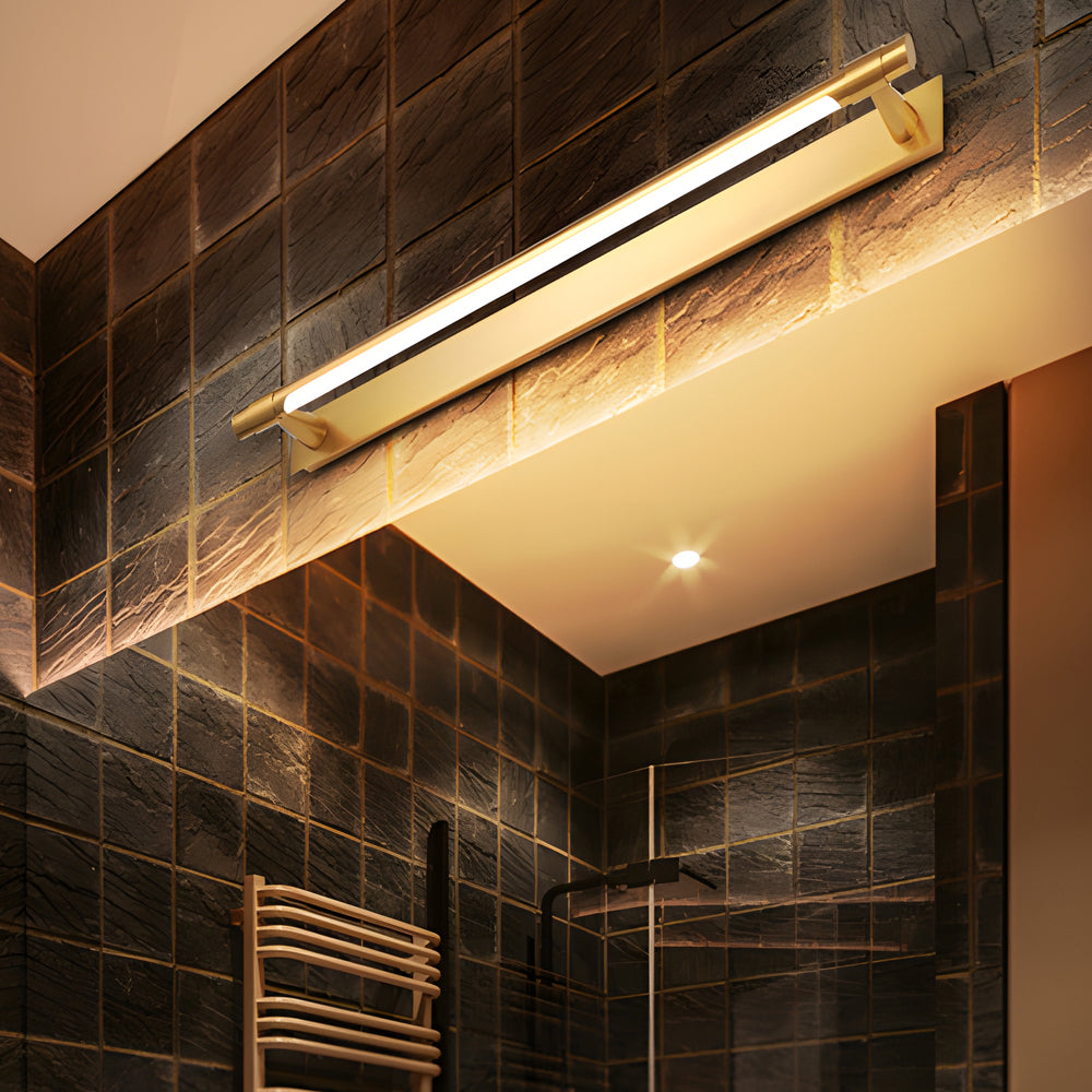 Black and gold vanity light casting a gentle glow in a modern bathroom.