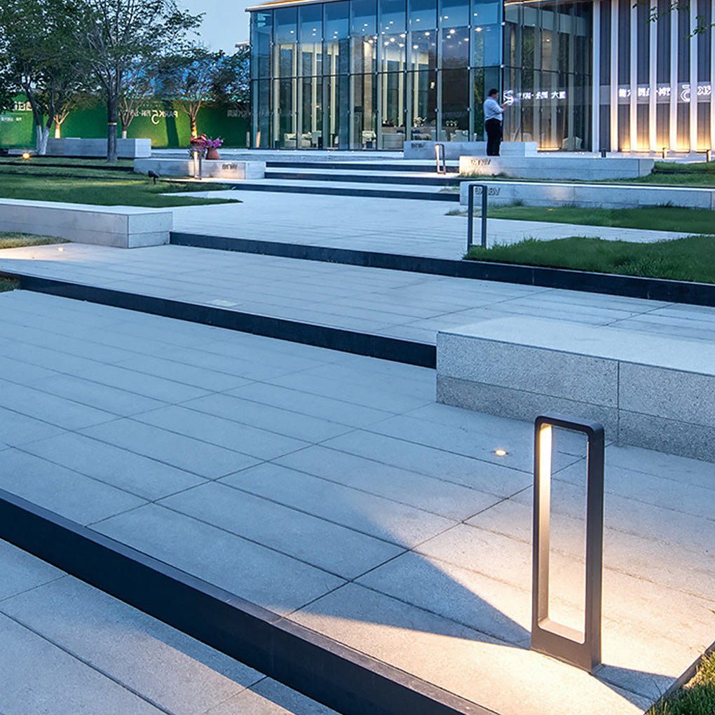 Black bollard lights enhancing a contemporary garden with a minimalist design.