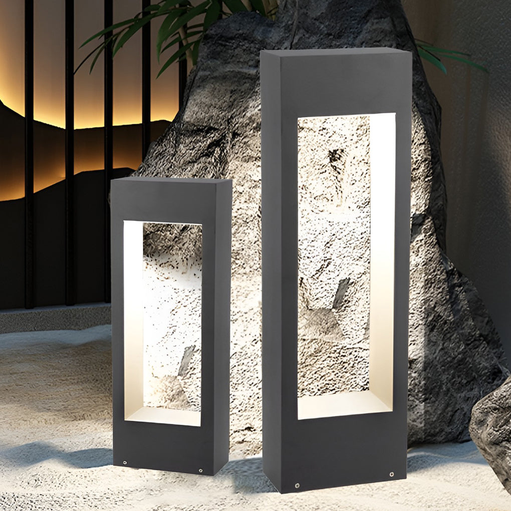 Pair of black bollard lights used as decorative outdoor lighting near stone feature.