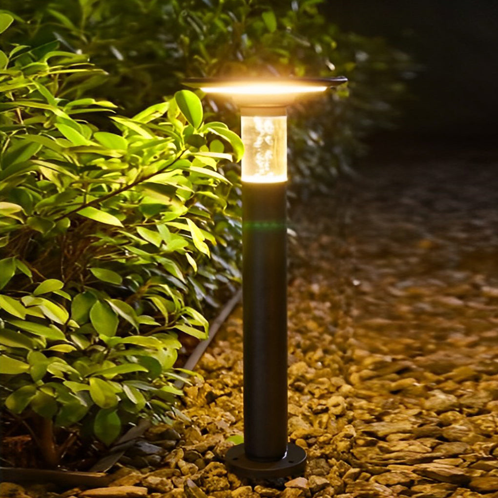 Black brass path lights providing soft illumination along a stylish driveway.
