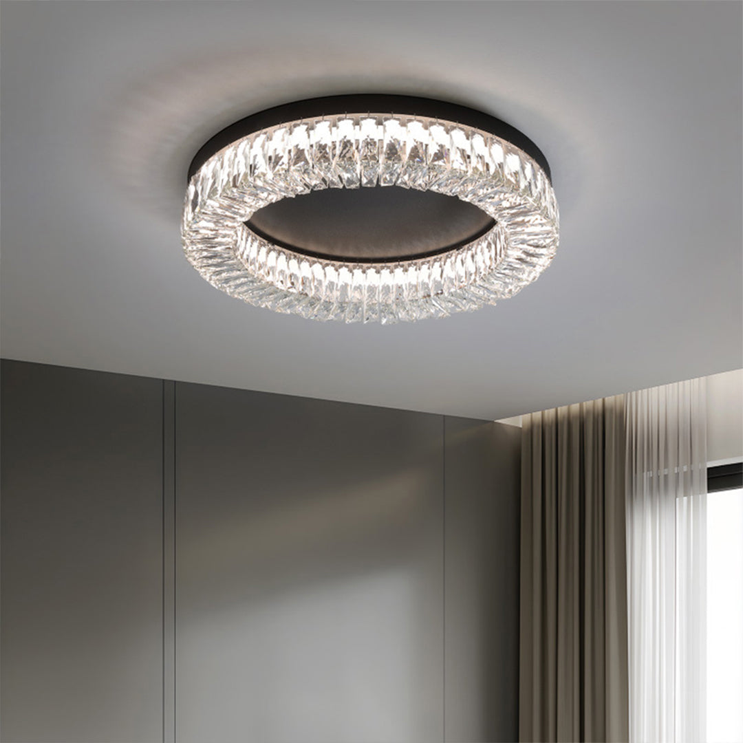 Black ceiling flush mount light installed in minimalist bedroom with grey walls and neutral bedding.