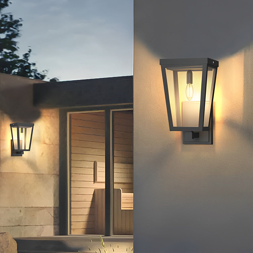 Black exterior LED wall lantern providing warm light near a wooden door and stone steps in a modern home.
