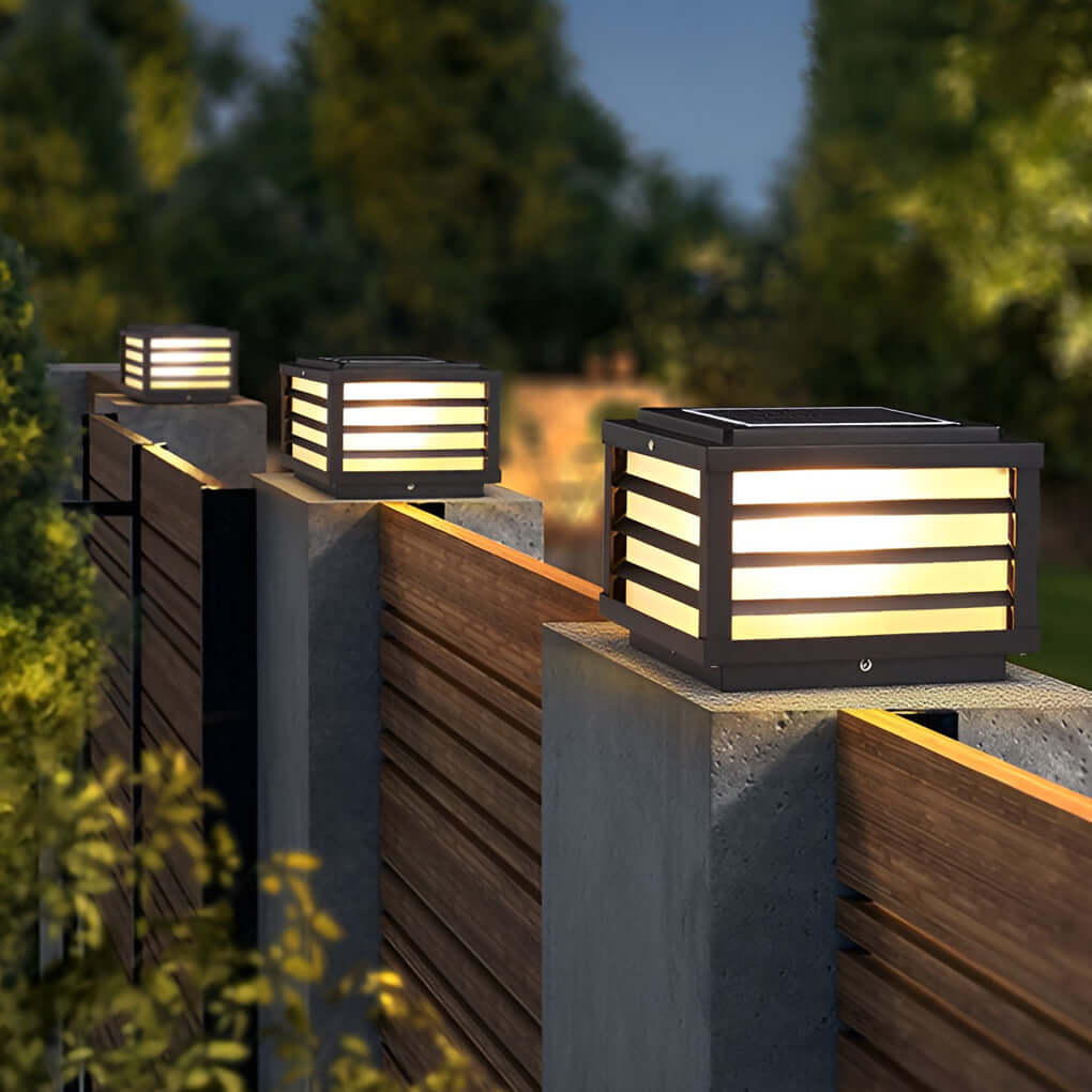 Black gate pillar lights with sleek rectangular design, mounted on a wooden fence for stylish outdoor lighting.