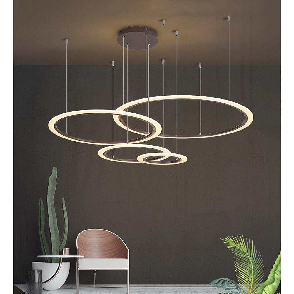 Black and gold multi ring chandelier displayed against a dark interior wall.