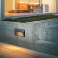 Black rectangular recessed wall light fixture with hooded design for directional outdoor illumination