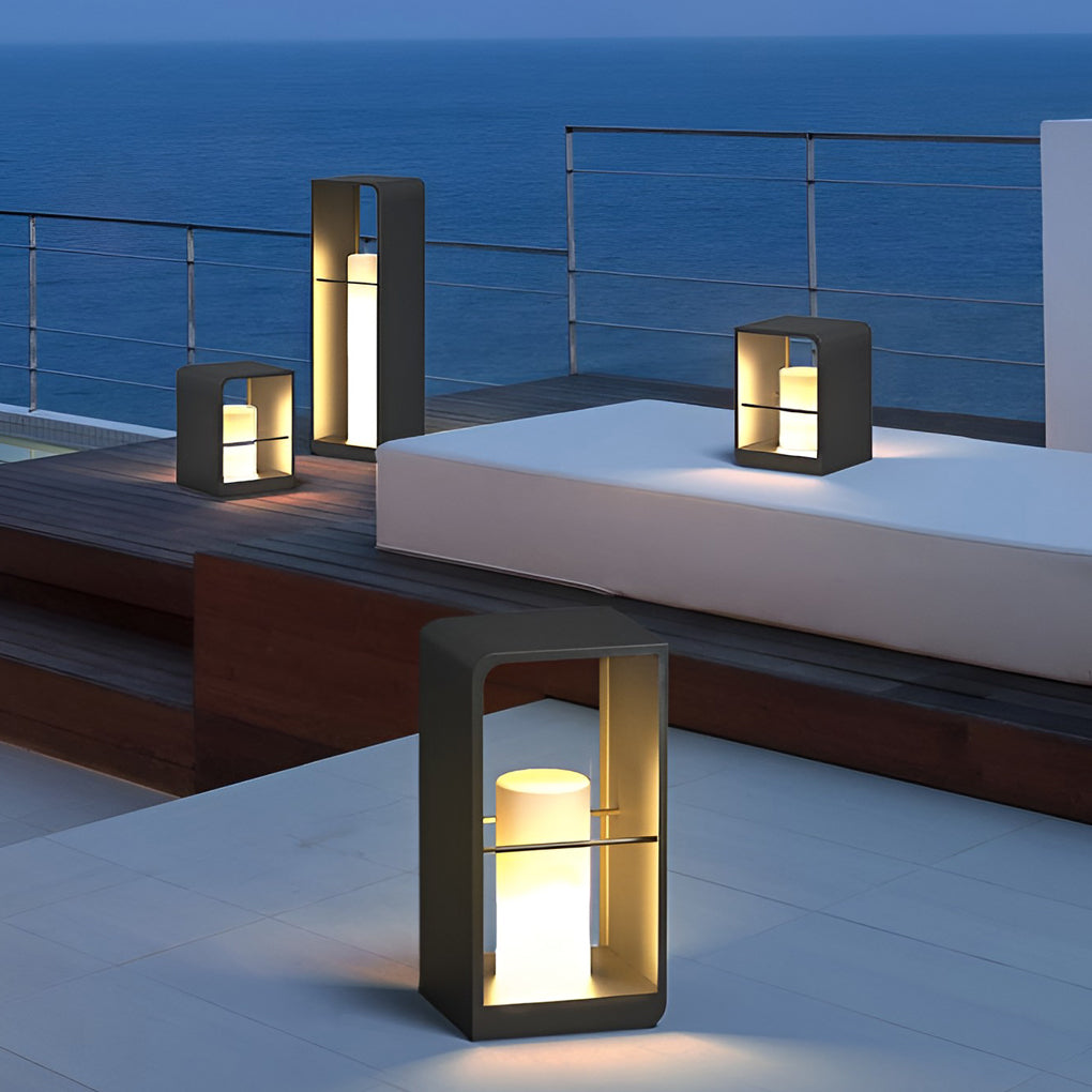 Black lantern outdoor light with minimalist design, placed on stone table beside pool loungers.