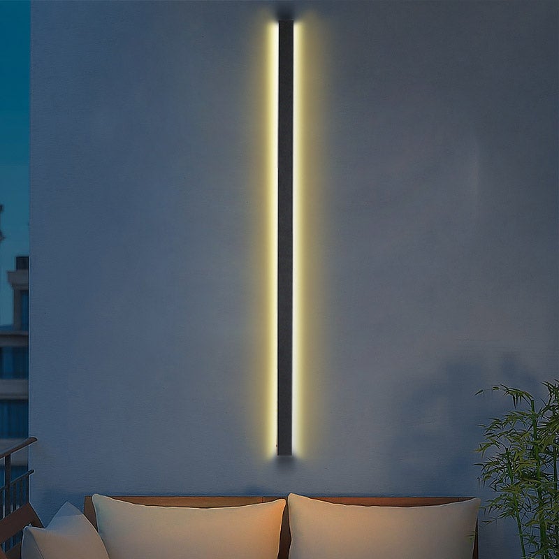 Black linear wall light enhancing a cozy outdoor seating area with soft light.