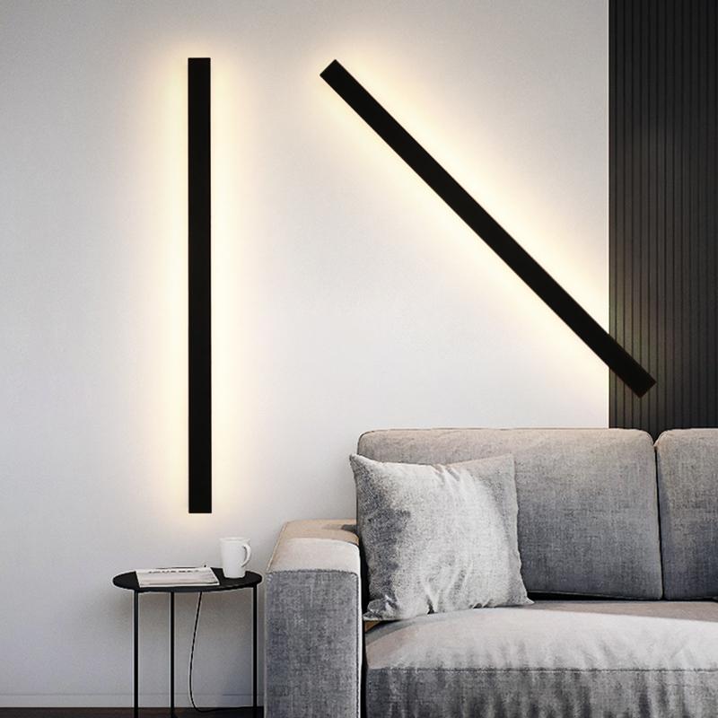 Black linear wall sconce providing ambient light in a contemporary interior.