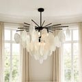 Striking black metal mother of pearl chandelier featuring cascading textured round discs suspended in a bright, elegant room.