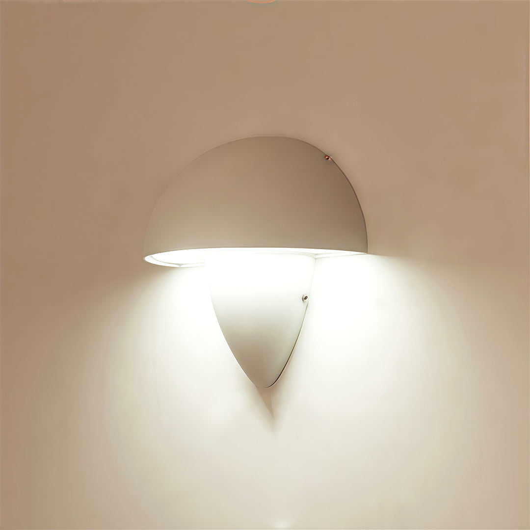Black mushroom wall light in an outdoor courtyard, highlighting the contemporary aesthetic with its sleek design.