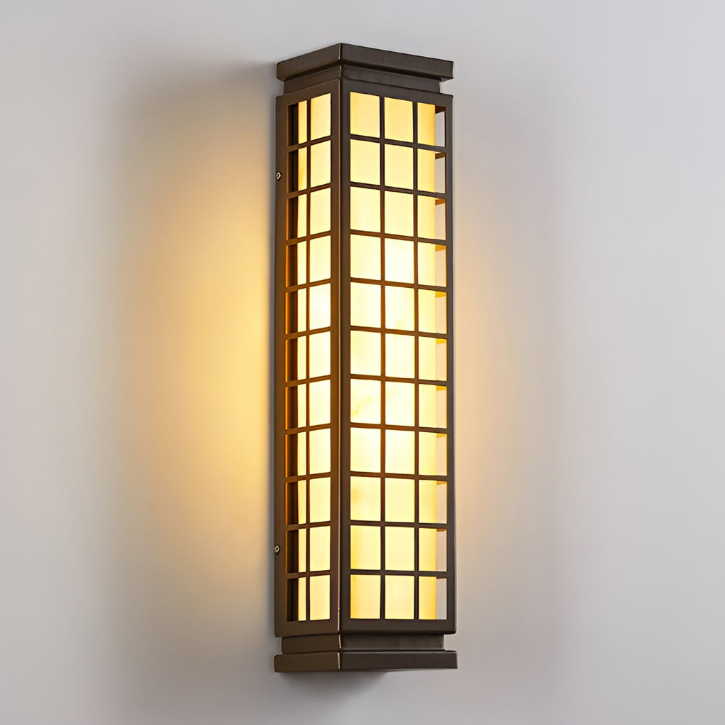 Black outdoor sconce light with grid design and warm lighting on plain white wall.