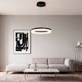 Modern black ring pendant light installed above a minimalist living room sofa with soft ambient lighting.