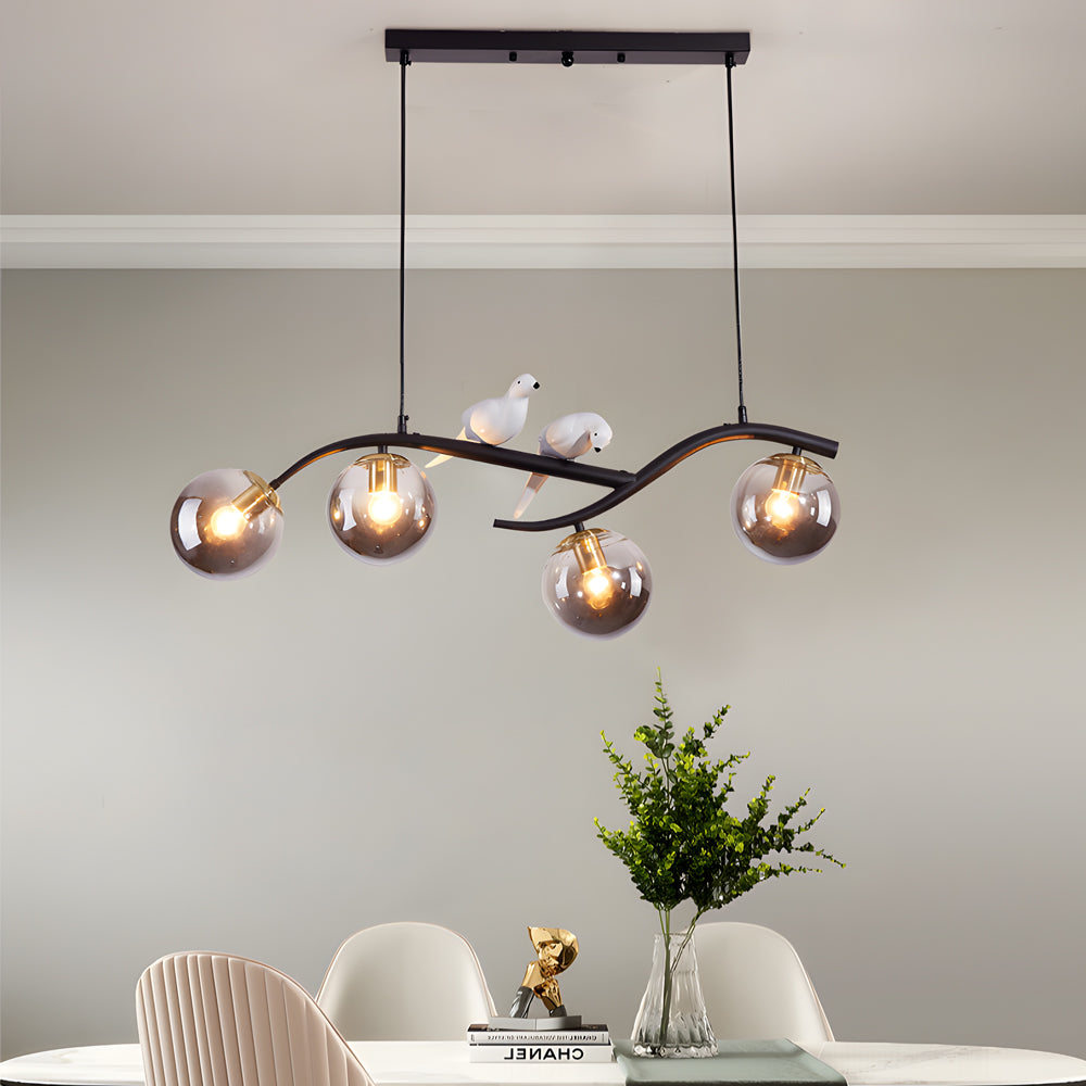 Black tree branch pendant light with amber glass globes.