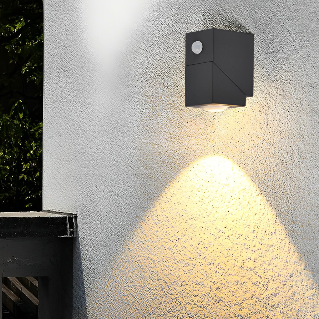 Black up down sconce outdoor mounted on textured wall providing upward and downward light for architectural detail.