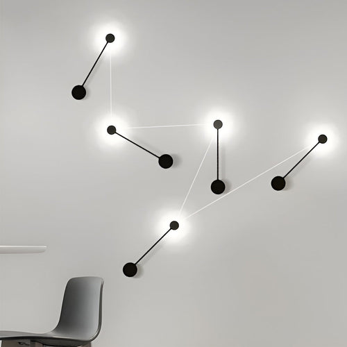 Black wall light illuminating a modern living room with warm directional glow.