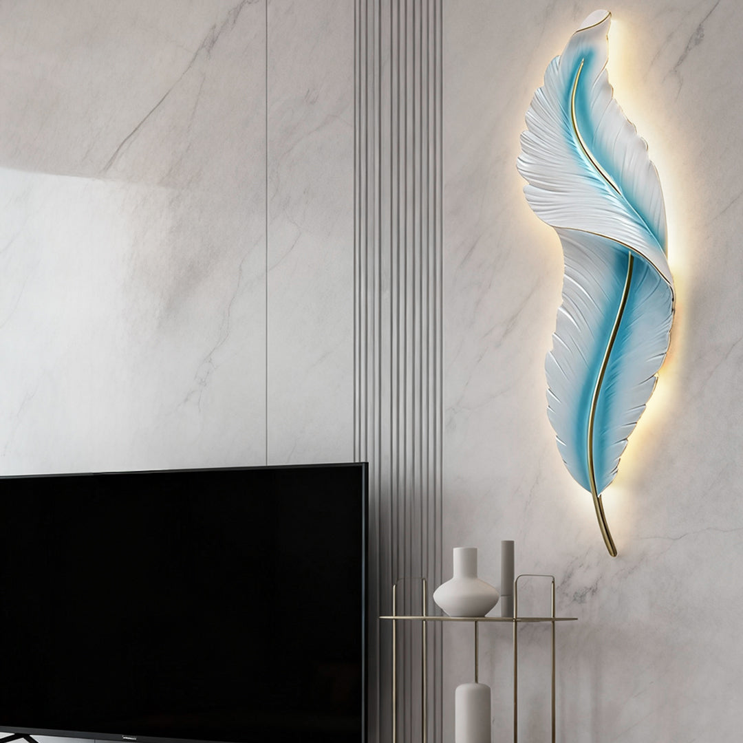Blue feather wall light mounted beside TV on marble wall with soft ambient glow.