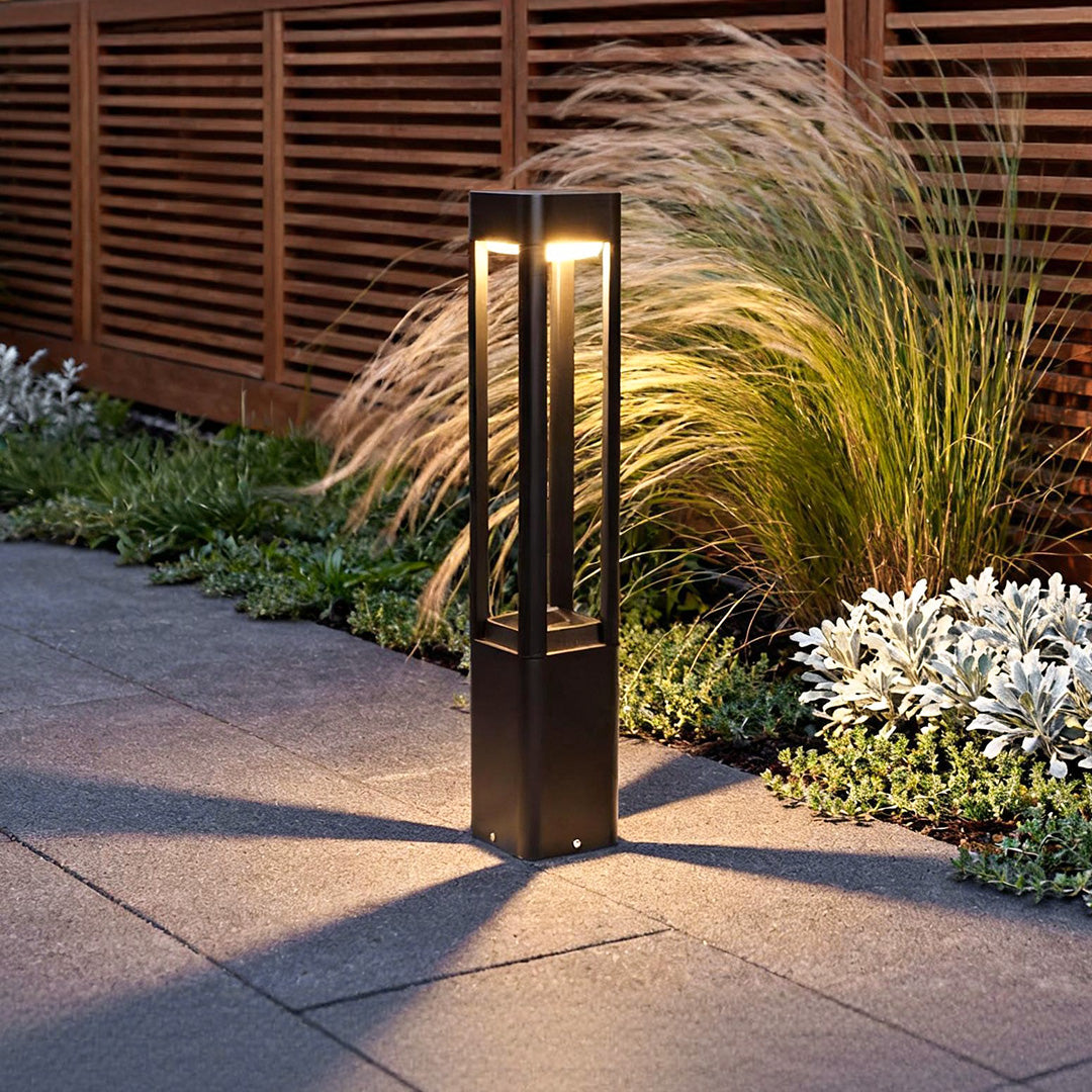 Modern bollard landscape lighting illuminating a garden pathway