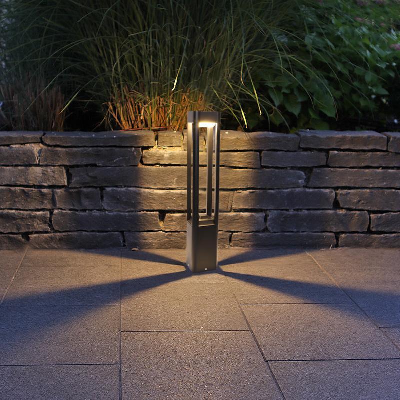 Bollard landscape lighting used as an accent beside a retaining wall