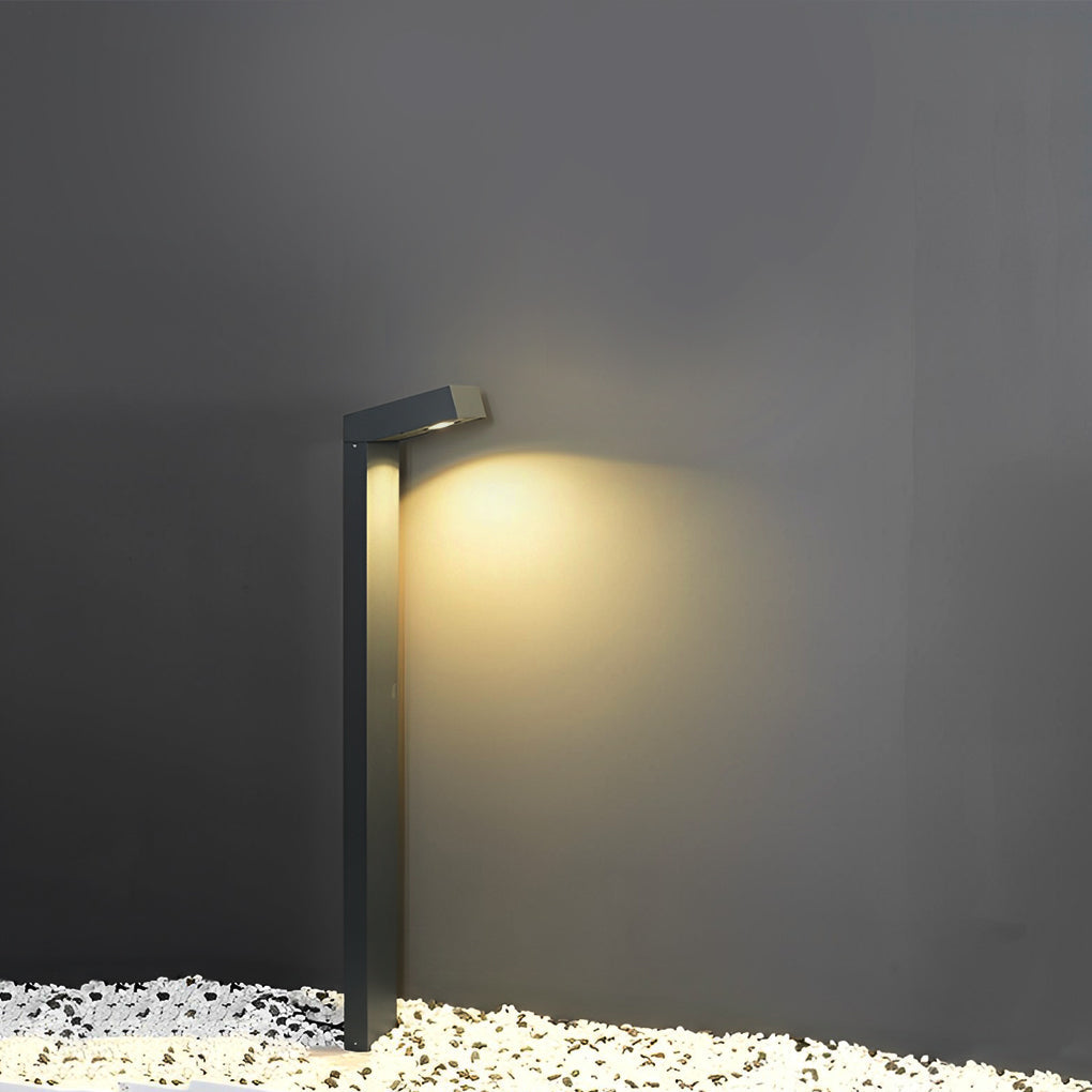 Bollard path light mounted on a dark wall, showcasing its sleek design and focused beam.