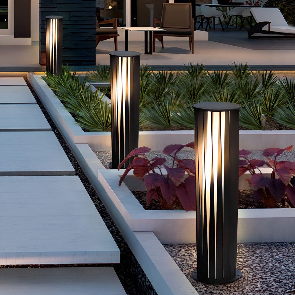 Bollard path lights aligned along a modern patio walkway with landscape design.