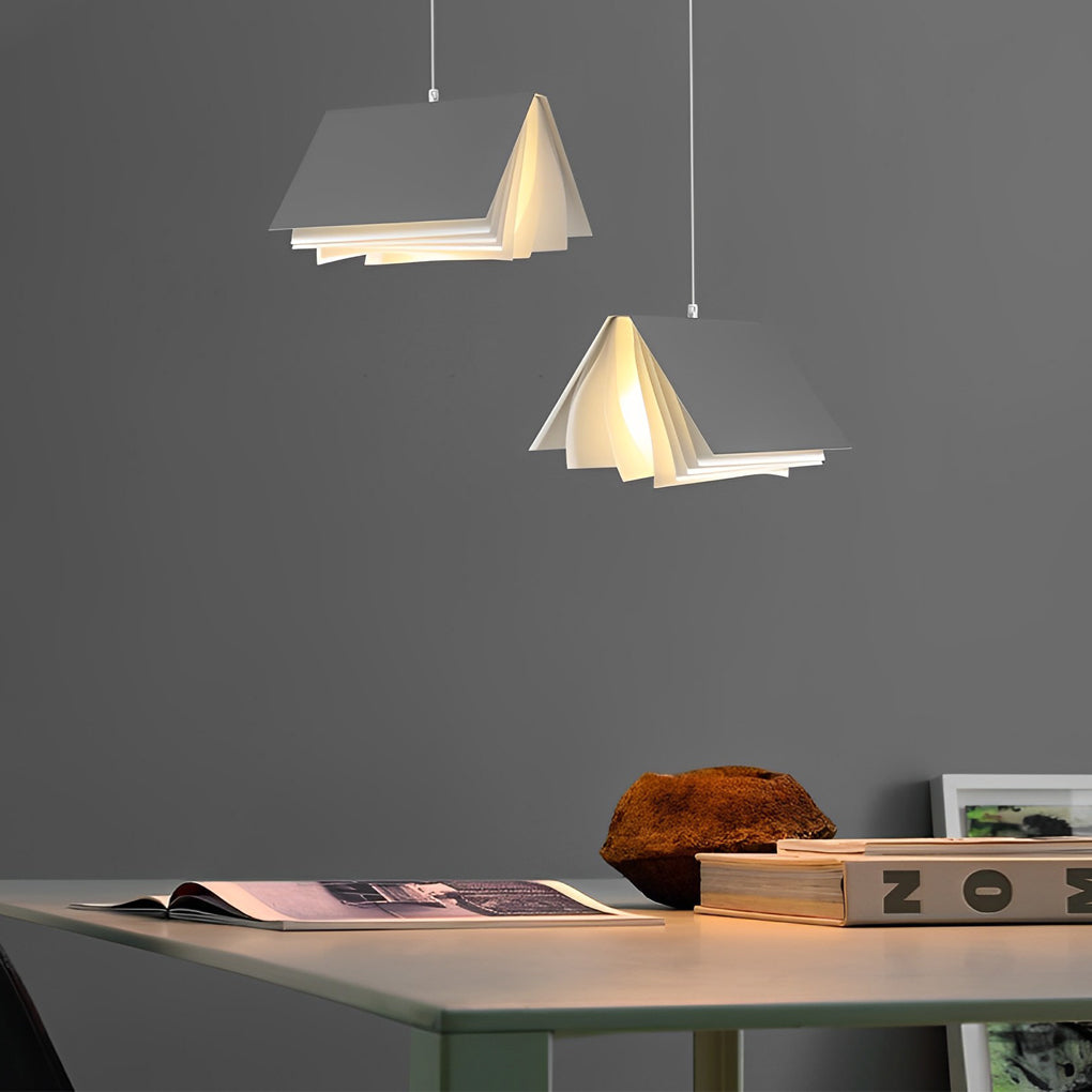 Contemporary book pendant light above a work surface, featuring warm light diffused through folded page-like panels.