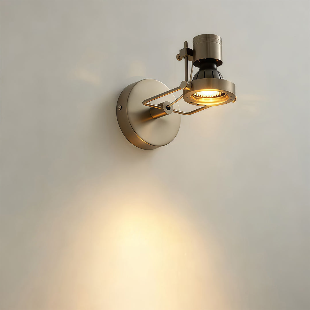 Brass industrial wall lights mounted on white interior wall with vintage spotlight design creating warm glow