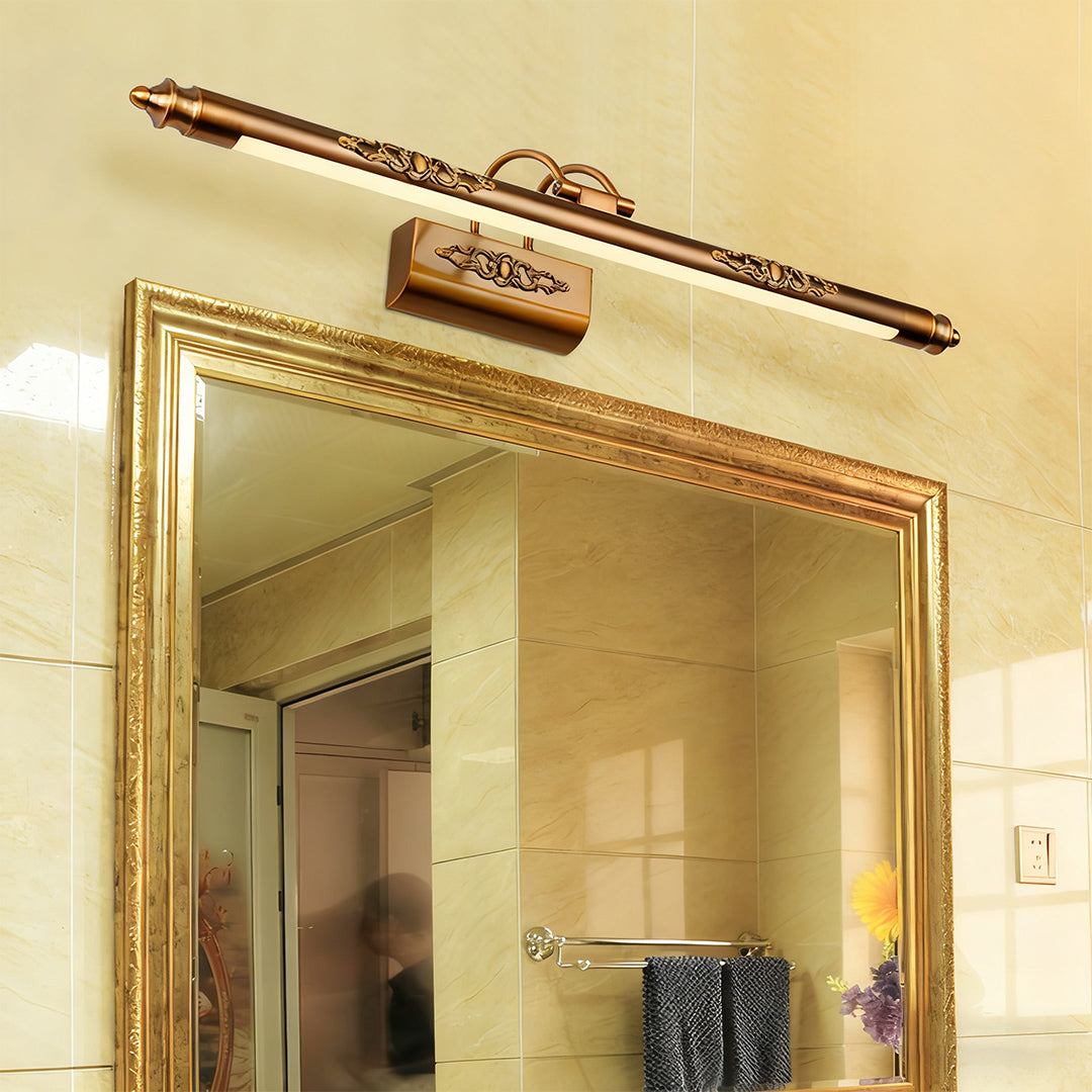 Brass bathroom vanity light fixtures mounted above ornate gold mirror creating elegant ambiance
