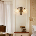 Brass wall lights enhancing classic bedroom with ornate mirror and neutral color palette