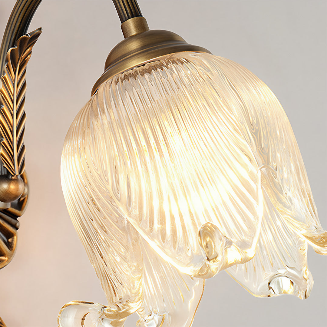 Close-up detail of brass wall lights showing textured glass shade and braided arm design